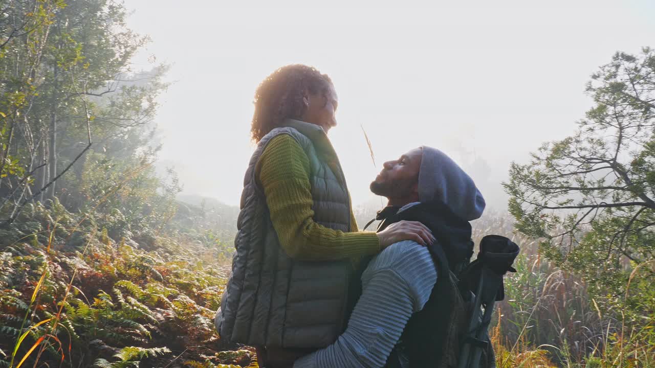 幸福多情的年轻夫妇在阳光明媚的秋林里徒步旅行视频素材