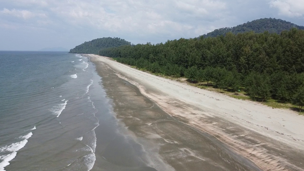 4K运动的软波和蓝色的海洋在沙黑色的海滩背景视频素材