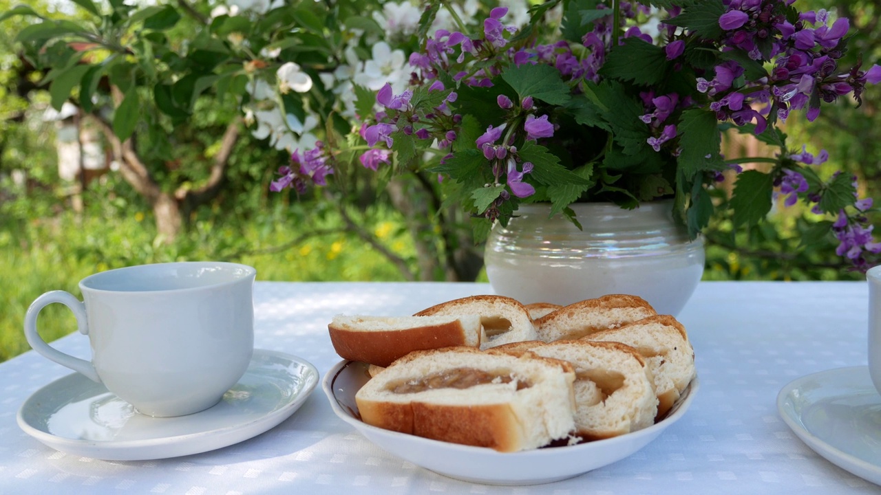 花园里的桌子上放着馅饼和两个茶杯视频素材