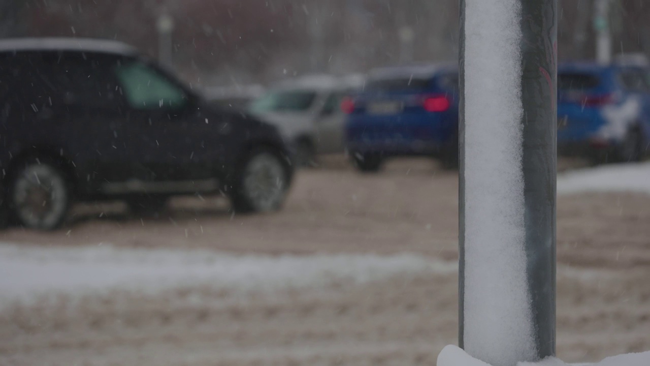 大雪期间的城市道路。汽车在冬天的泥和雪中行驶视频素材