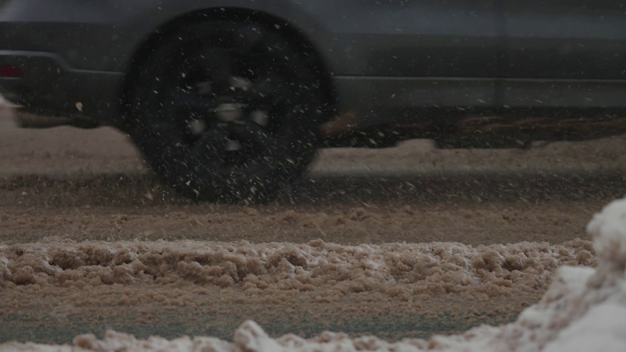 大雪期间的城市道路。汽车在冬天的泥和雪中行驶视频素材