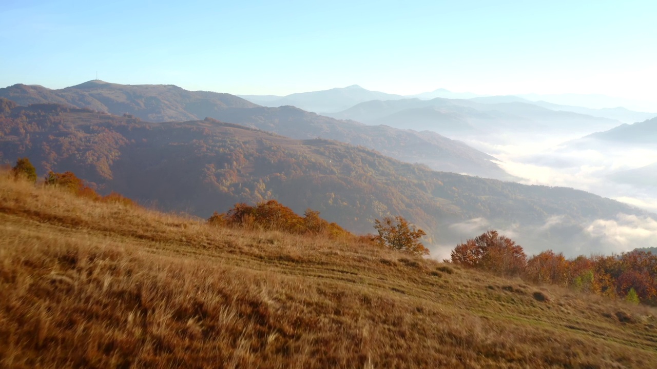 阳光明媚的一天，一架无人机飞过宁静的秋山。视频素材