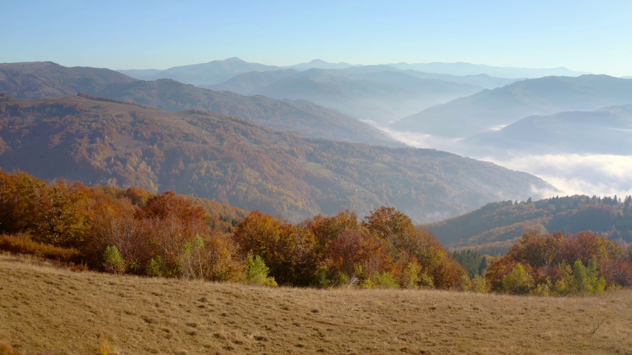 阳光明媚的一天，一架无人机飞过宁静的秋山。视频素材