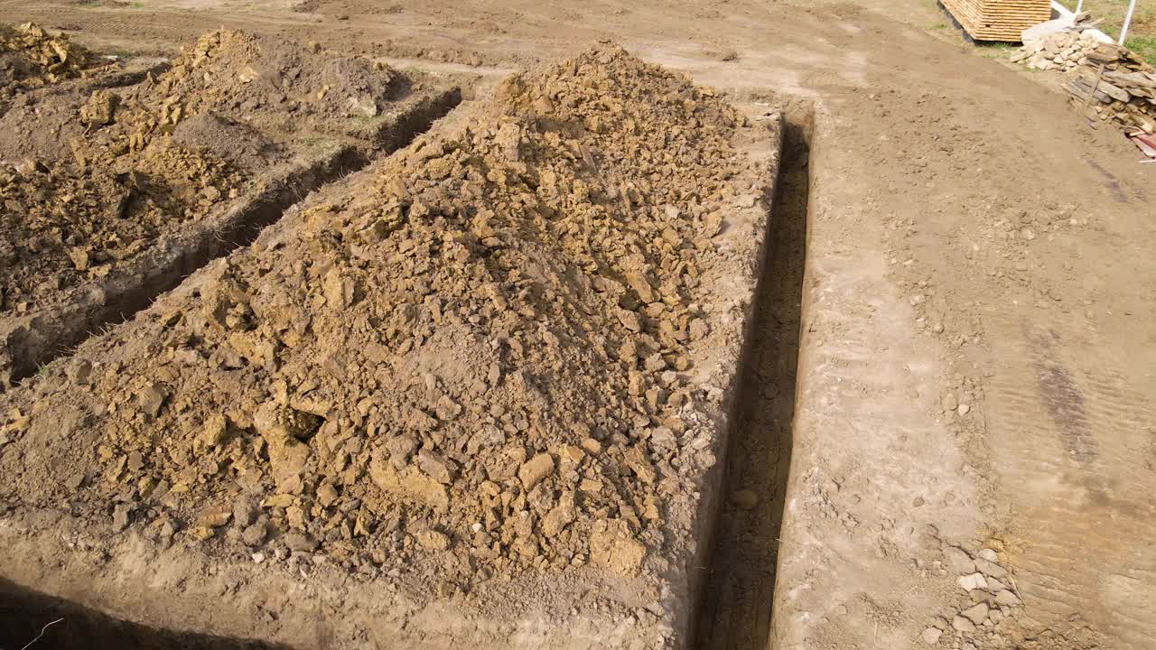 在建筑工地为新建住宅混凝土地基的建筑工程挖沟视频素材