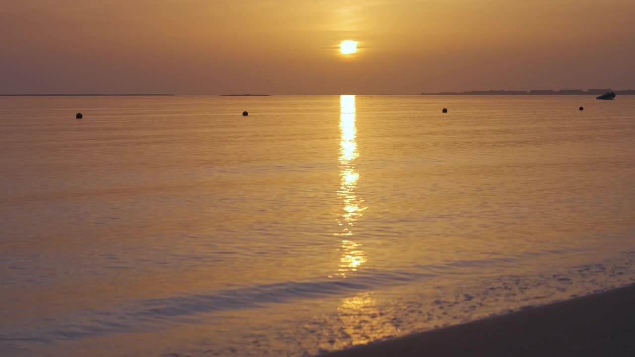 平静的海岸，在日出时，海浪拍打着沙滩视频素材