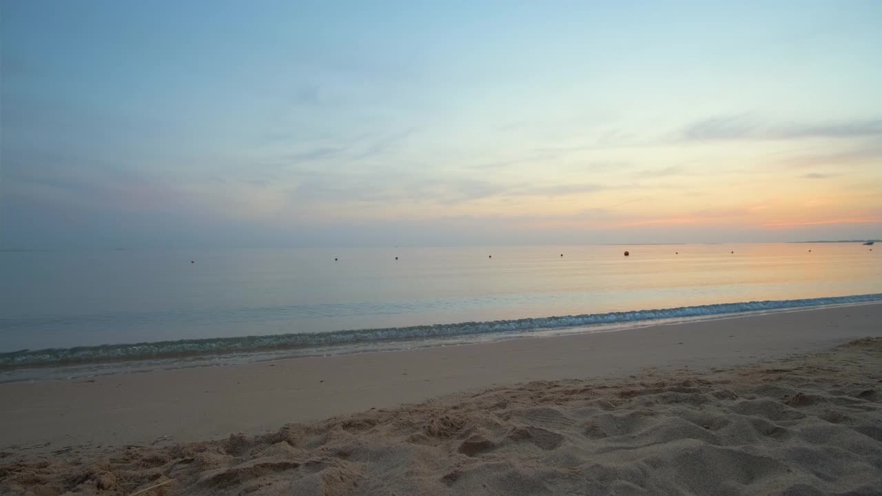 平静的海岸，在日出时，海浪拍打着沙滩。视频素材