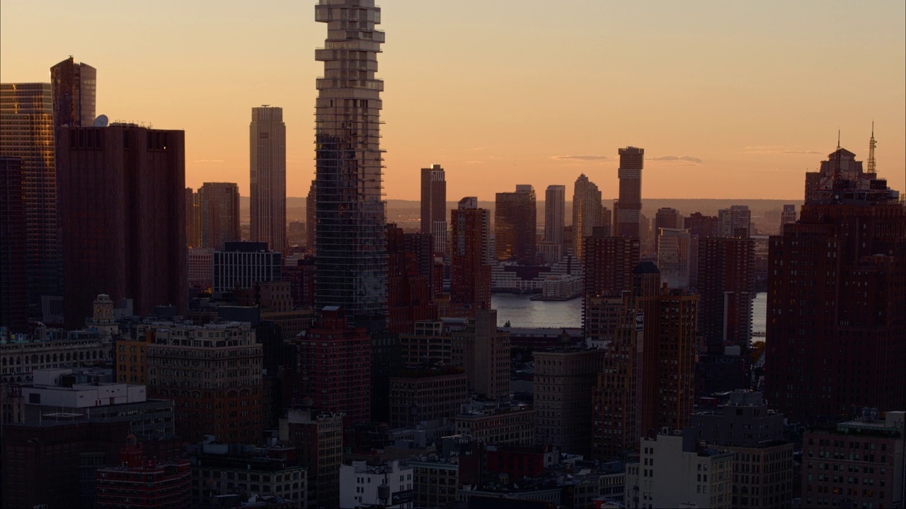 日落时，泽西城横跨曼哈顿下城和赫斯顿河的远景。航拍镜头与向后和向下的相机运动。视频素材