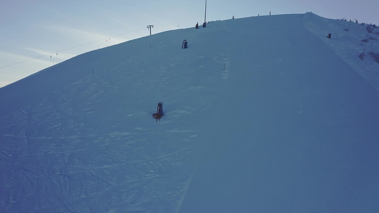 鸟瞰一个阳光明媚的雪域冬季滑雪胜地Stöten与滑雪升降机视频素材