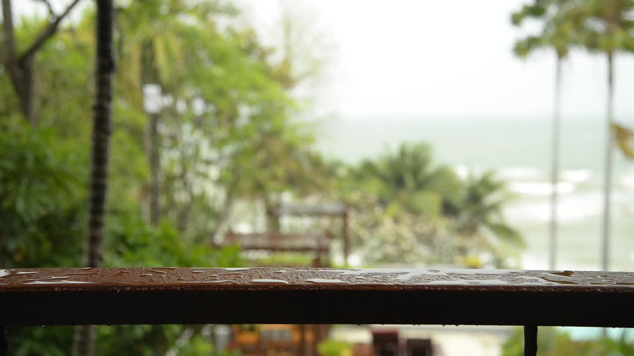 雨水滴落在阳台的木栏杆上。风雨交加的雨季视频下载