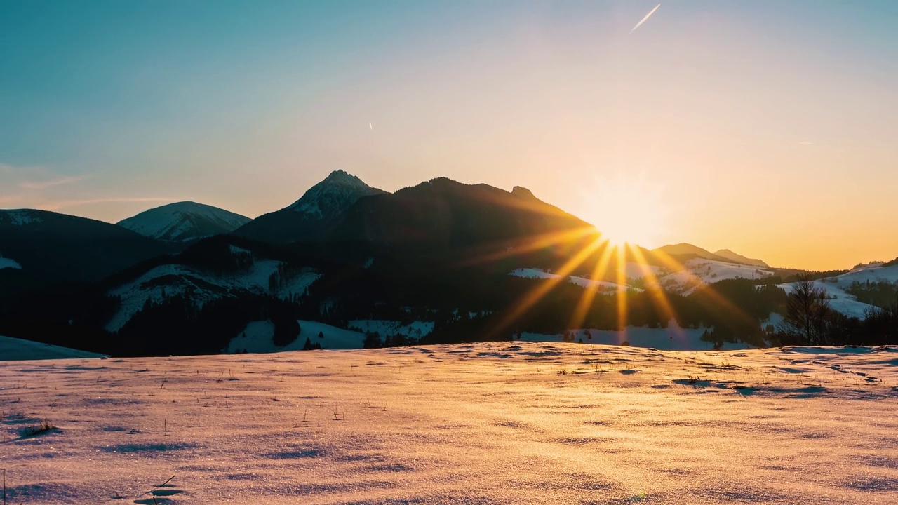 太阳下山在美丽的冬季自然风景在日落在寒冷的雪山景观时间流逝视频素材