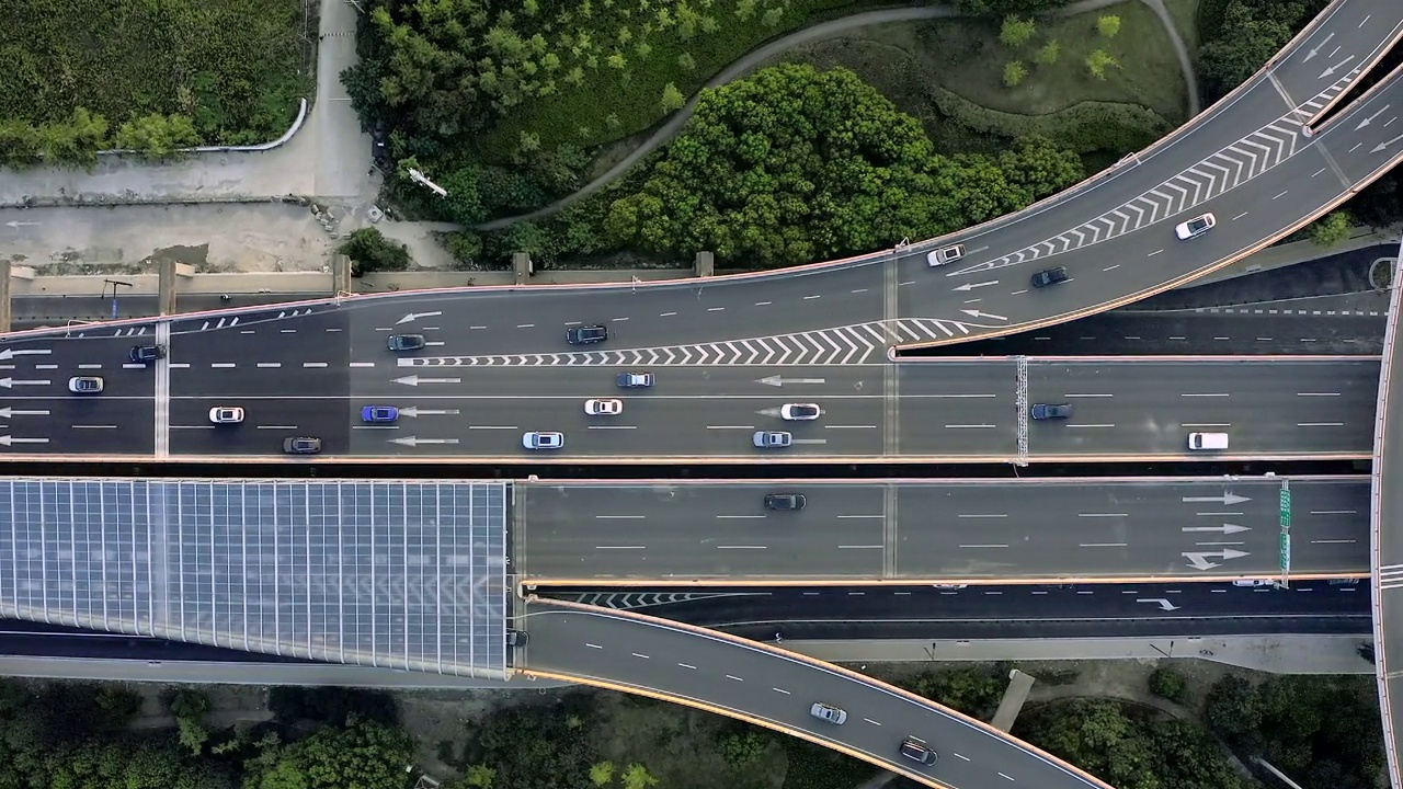 城市交通在街道交叉口的直线圆形环岛在水平鸟瞰图。几条道路的十字路口立交桥的坡度较大。视频素材