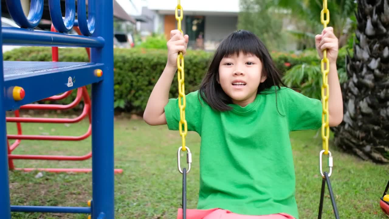 慢动作的中国孩子玩秋千，孩子们在操场上玩得很开心视频素材