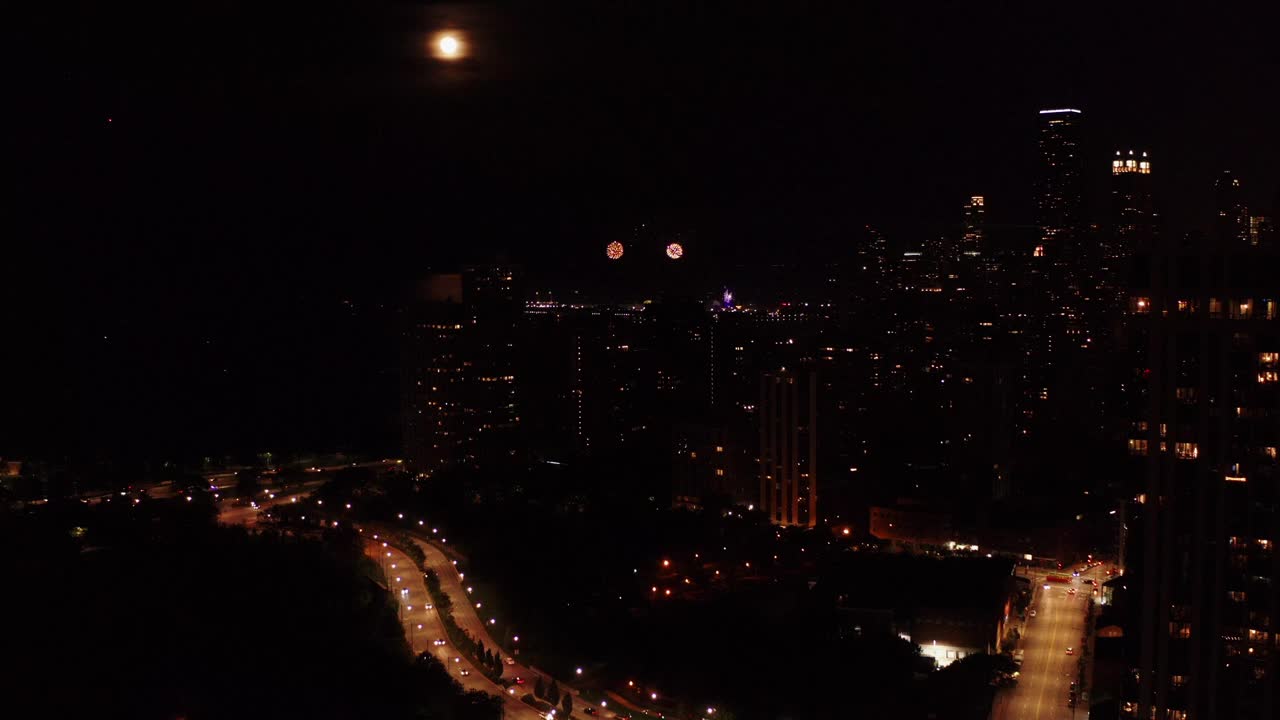 夜间城市道路的鸟瞰图。城市夜晚生活的全景。无人机在夜晚飞过城市上空。烟花在摩天大楼。视频素材