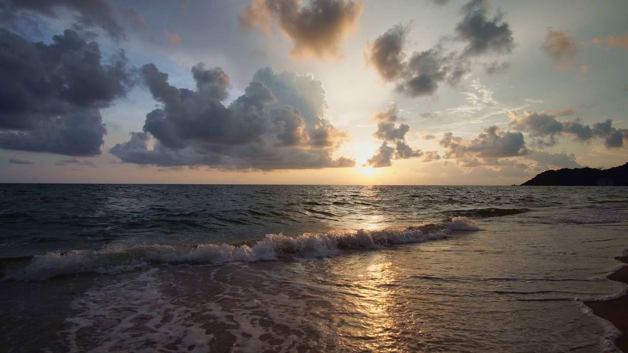 美丽的日落，阳光照在沙滩上，海浪冲刷着沙滩视频素材