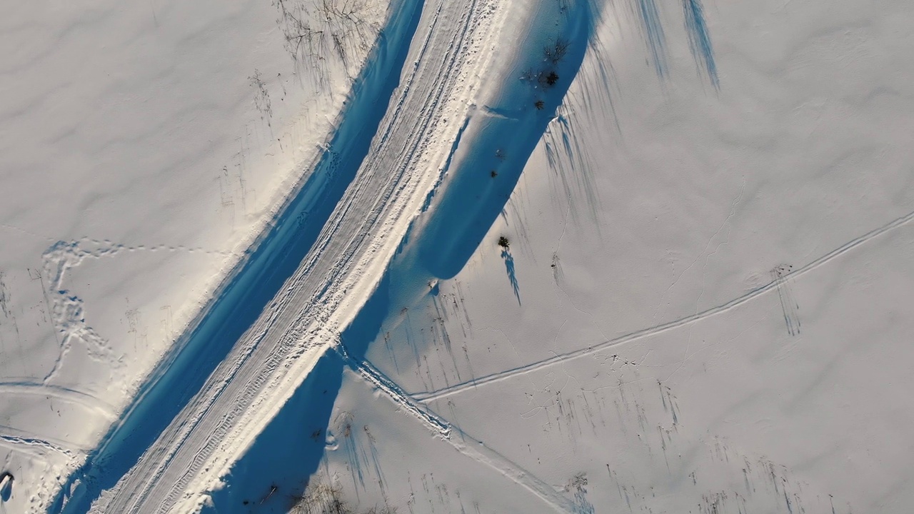 空中俯瞰4k视图的冬季拖拉机清除道路。路雪。视频素材