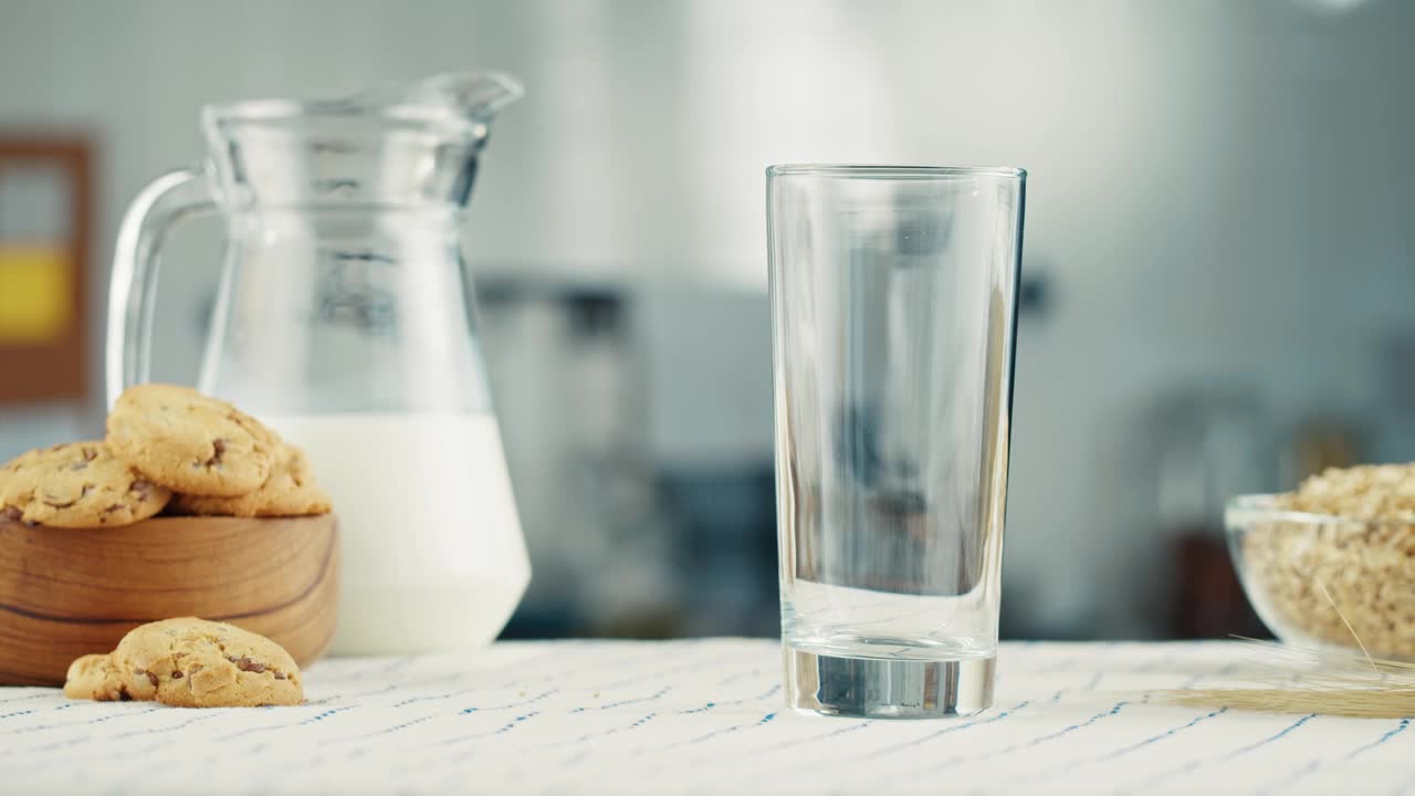 杯子里的牛奶特写。玻璃与酸奶、乳制品的概念。早上喝新鲜的无乳糖牛奶。视频素材