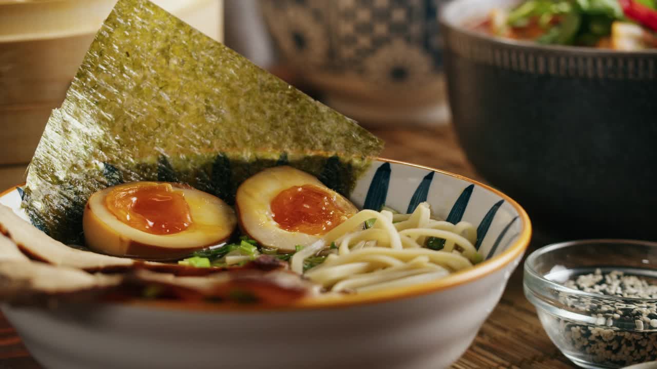 日本拉面亚洲汤面配牛肉或鸡肉，蘑菇和鸡蛋，厨师在传统的韩国中餐烹饪。接近美味的越南美食。视频素材