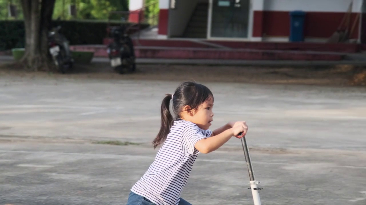 快乐的妈妈和孩子们在夏天的公园里骑着滑板车击掌。在户外玩滑板车的孩子们。儿童休闲活动和户外运动视频素材