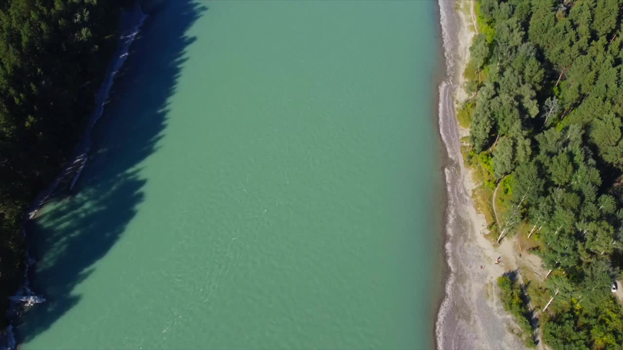 绿松石色的山间河流，点缀在针叶林和蓝天之中。用无人机录的。视频素材