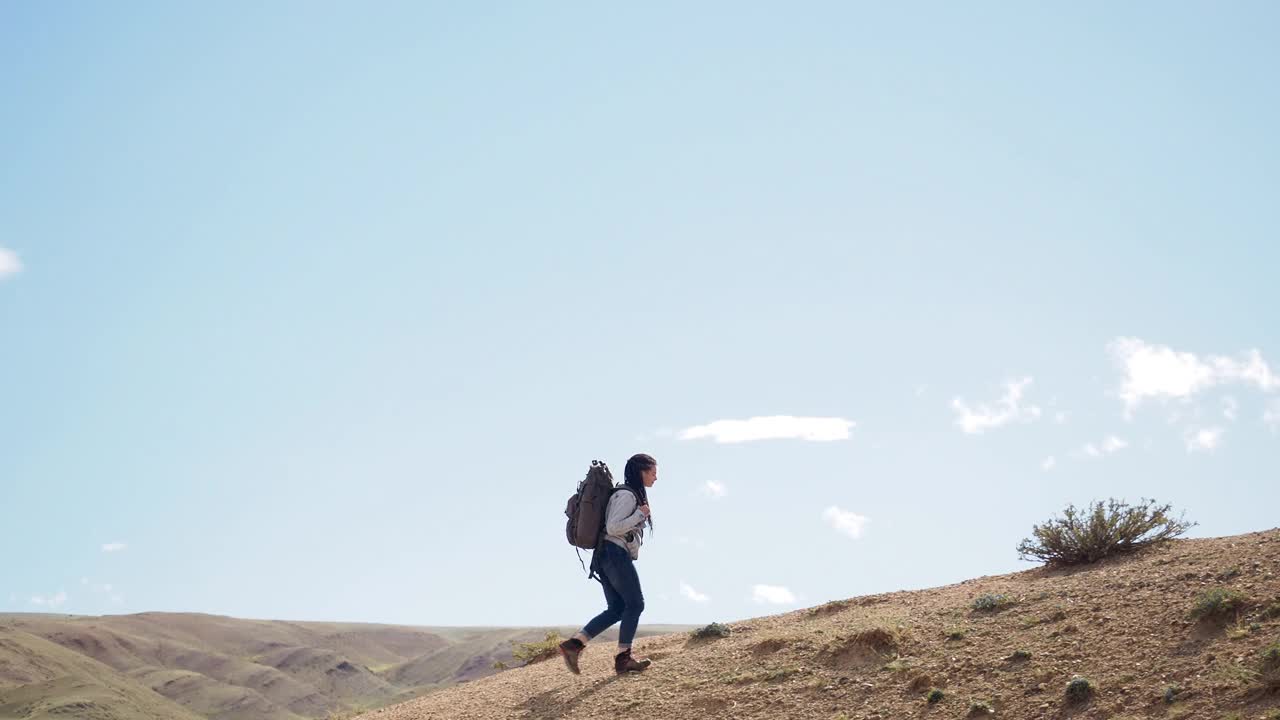 快乐的女徒步旅行者独自在沙漠徒步旅行视频素材