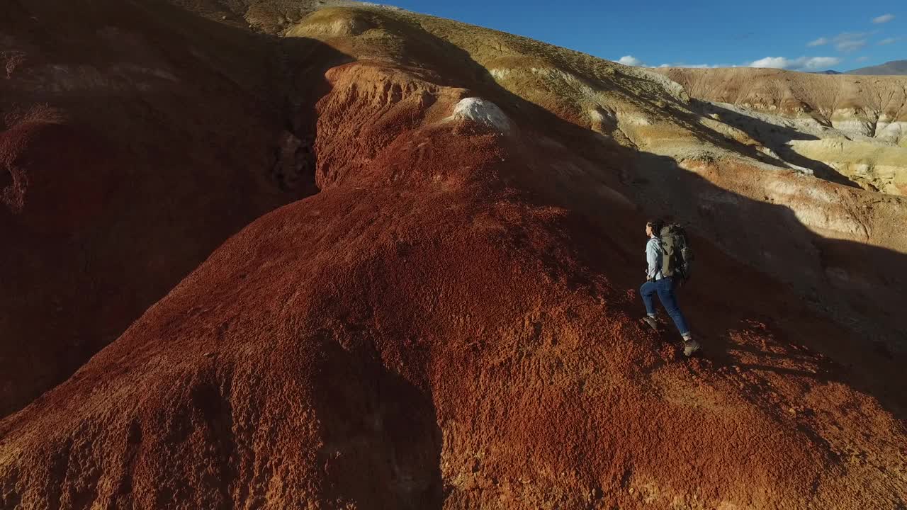 一名女徒步旅行者在红色的山脉点燃了一枚烟雾弹视频素材