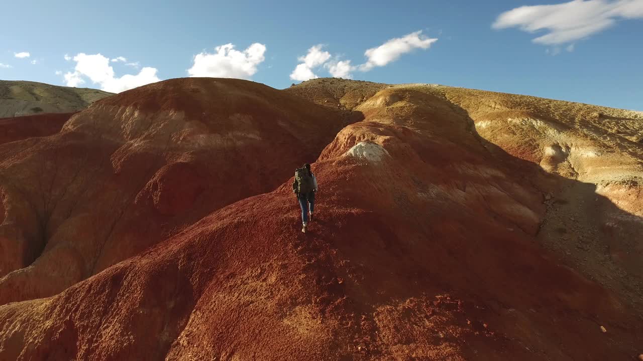 一名女徒步旅行者在红色的山脉点燃了一枚烟雾弹视频素材