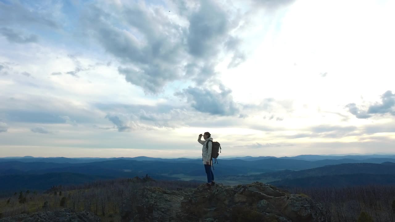 徒步旅行者站在山顶环顾四周视频素材