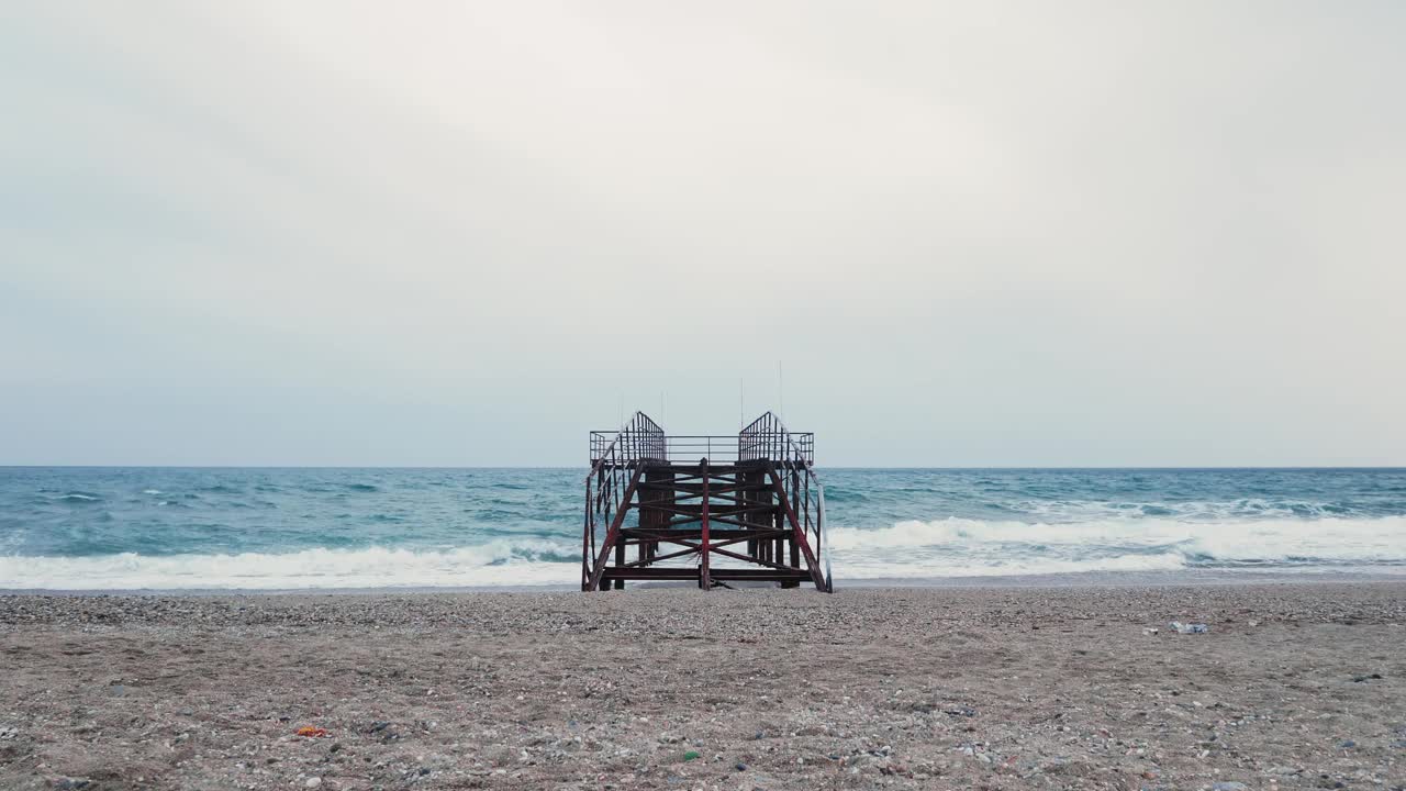 海上的铁码头。旧的生锈的铁码头在海滩上。海浪拍打着沙滩视频素材