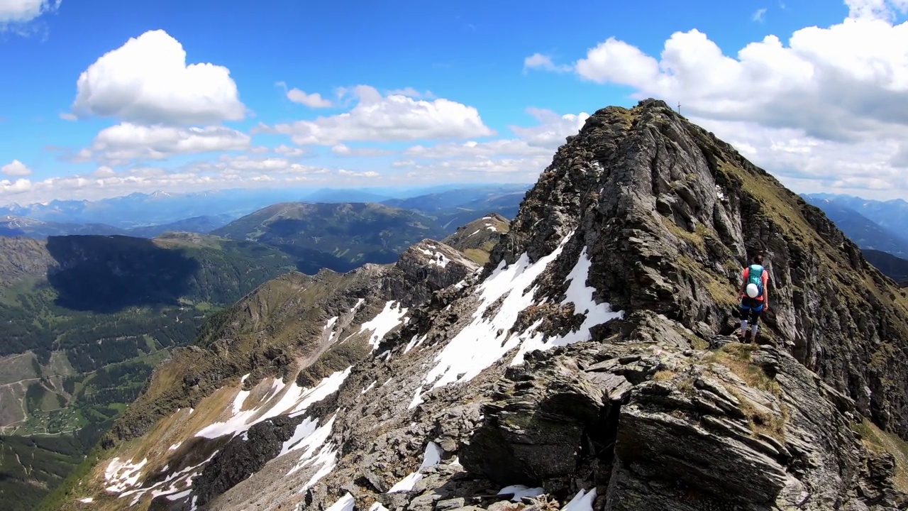 重申-一个女人徒步在奥地利阿尔卑斯山欣赏卡林西亚高山景观，高牛头。旅游热视频素材