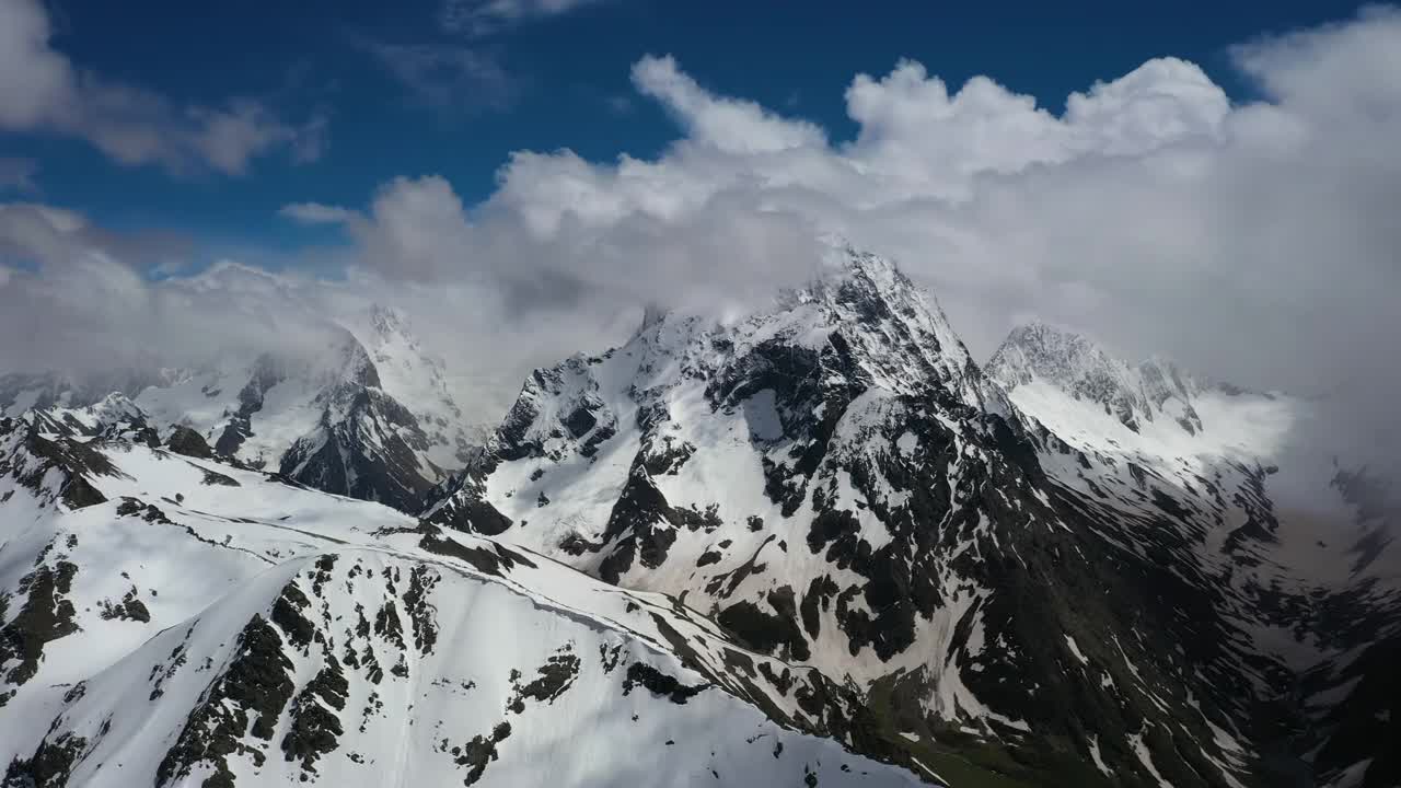 飞机穿越高山云层，飞过美丽的雪峰和冰川。视频素材