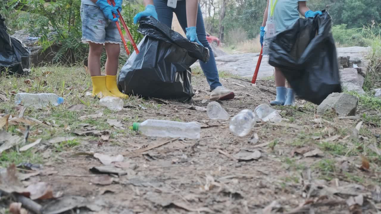 一群亚洲志愿家庭在河边收集垃圾和塑料。把垃圾放在垃圾箱里，帮助保护环境。世界环境日视频素材