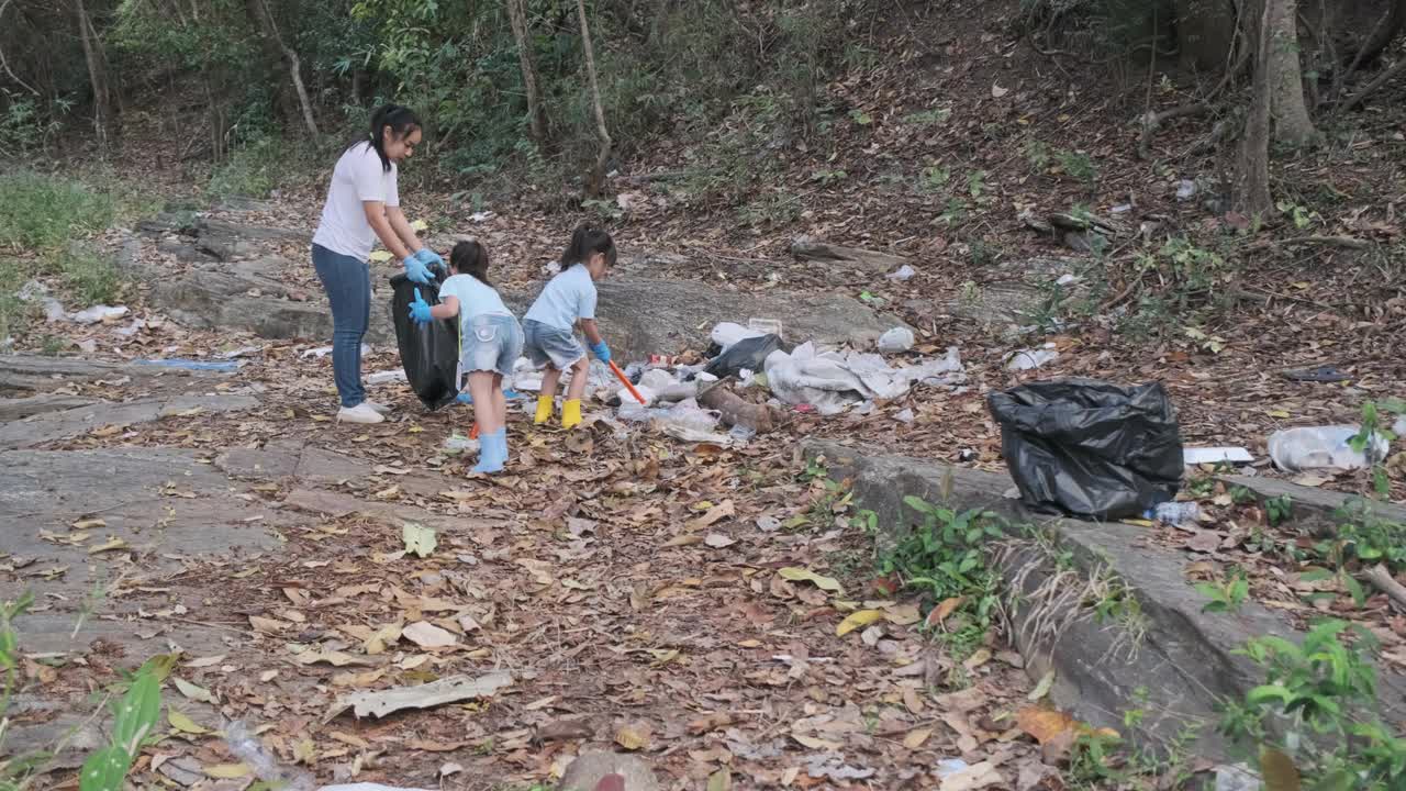 一群亚洲志愿家庭在河边收集垃圾和塑料。把垃圾放在垃圾箱里，帮助保护环境。世界环境日视频素材