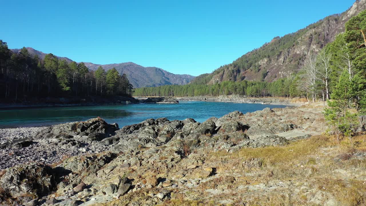 用无人机在岩石堤岸和河水上低空飞行视频素材