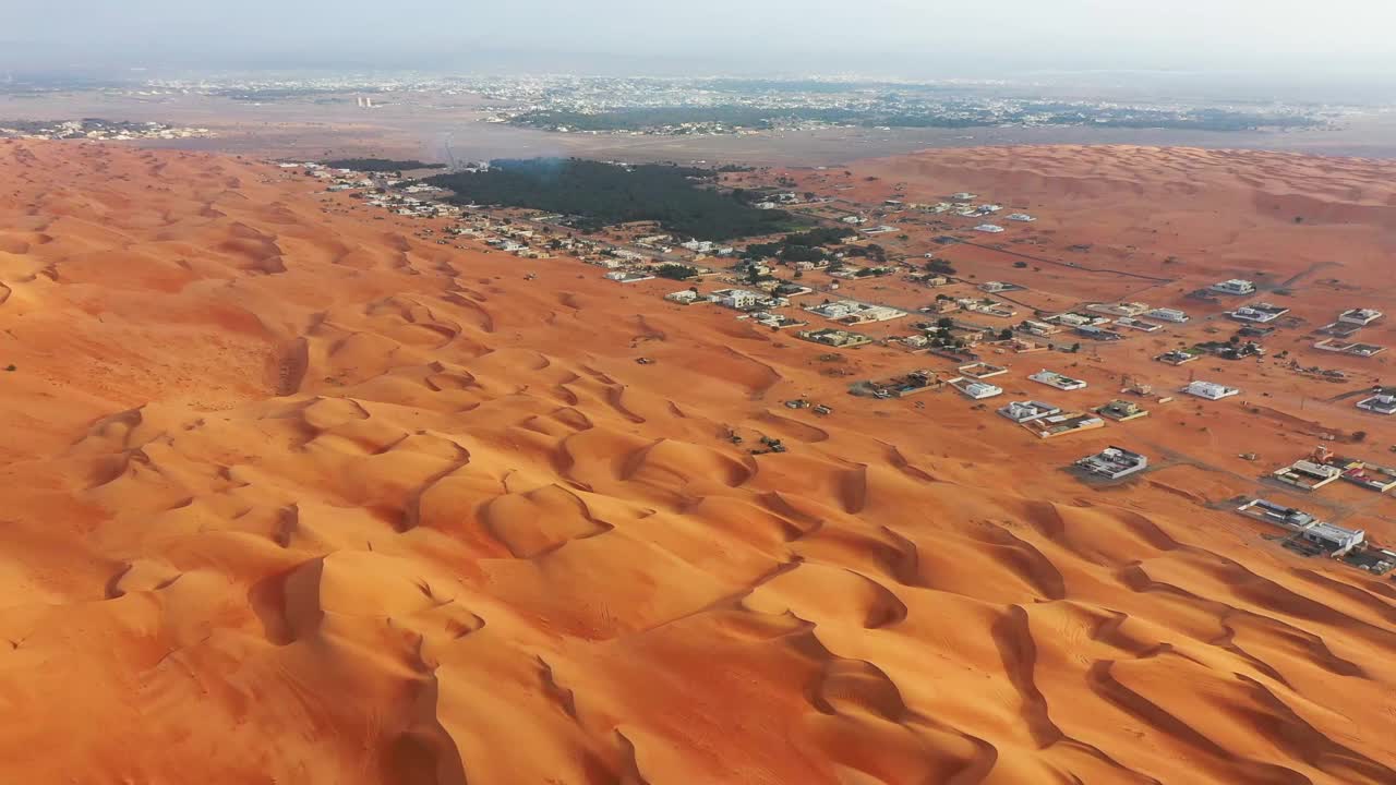 俯瞰海湾国家阿曼的Bidyah村庄周围的沙丘视频素材