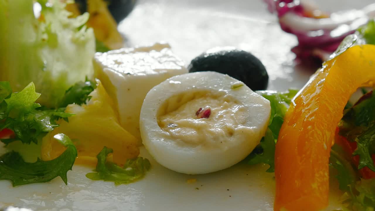 一个女孩用叉子从一个白色的盘子里吃蔬菜沙拉视频下载