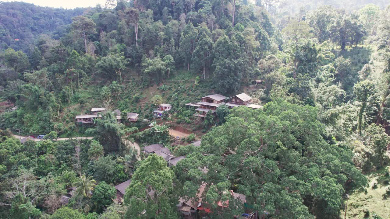 鸟瞰图，在乡村热带雨林的山谷中，传统的乡村与木制家庭住宿视频素材