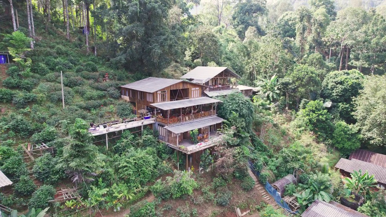 鸟瞰图，在乡村热带雨林的山谷中，传统的乡村与木制家庭住宿视频素材