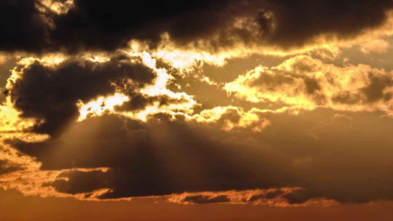戏剧性的日落与太阳光线在天空中穿过橙色的分层云，时间推移视频素材