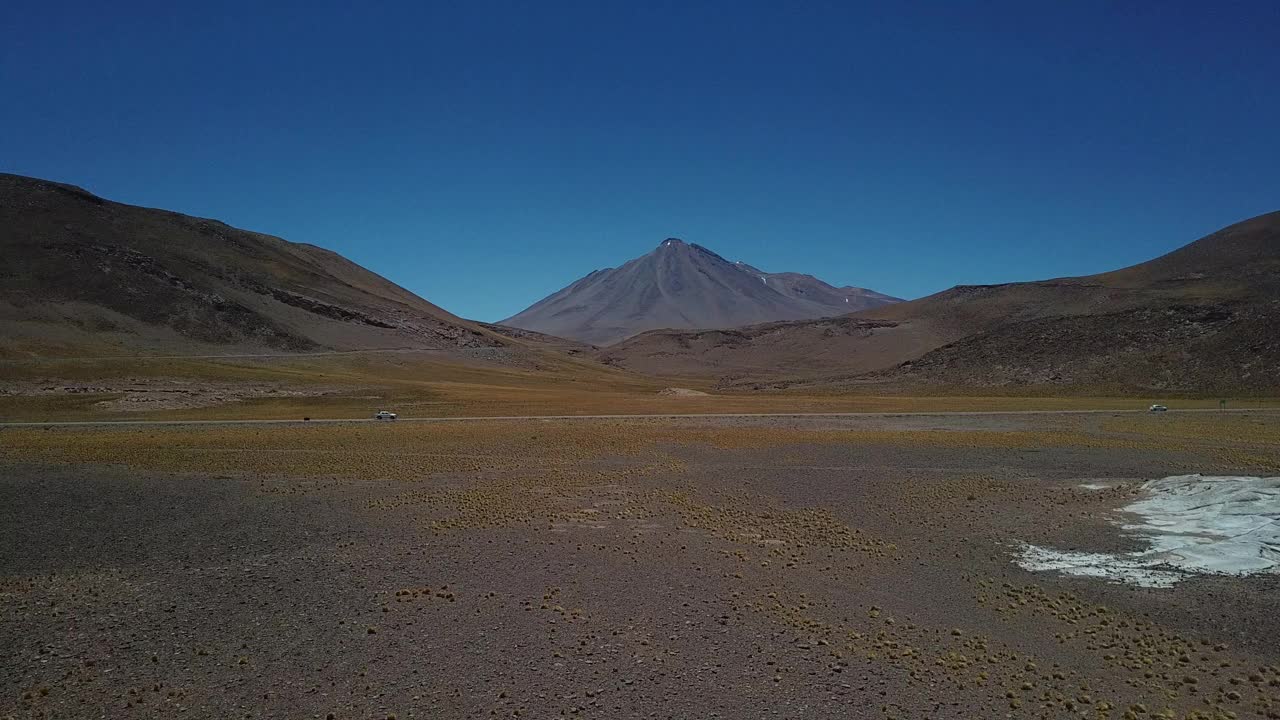 一辆孤零零的汽车行驶在智利阿塔卡马沙漠的道路上视频素材