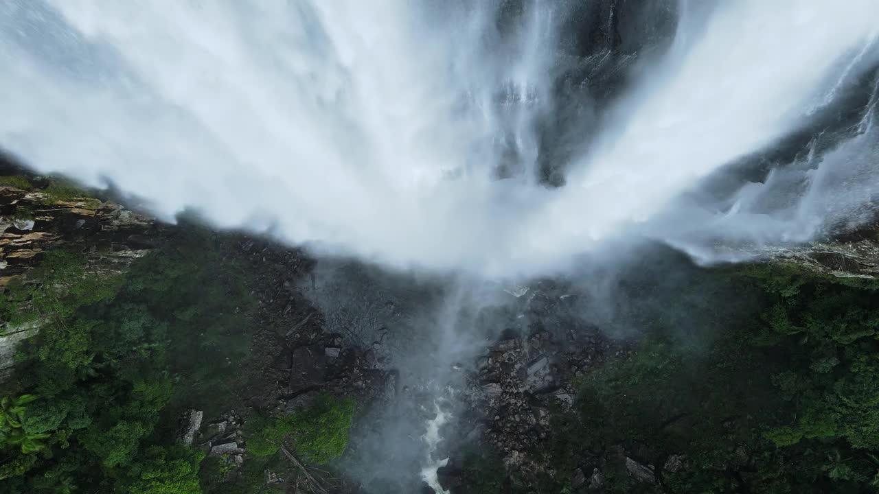 在茂密的热带雨林中，从雄伟的瀑布下倾泻而下的独特景观。无人机移动视图视频素材