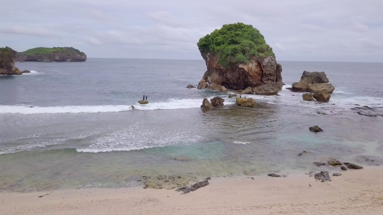 无人机拍摄热带海滩与珊瑚岛被海浪击中视频素材