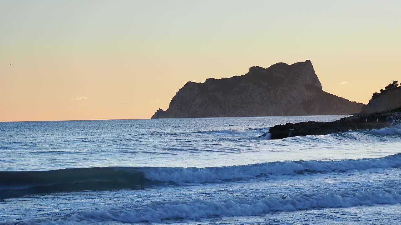 日落时海滩旁边的海岸线景观。视频素材