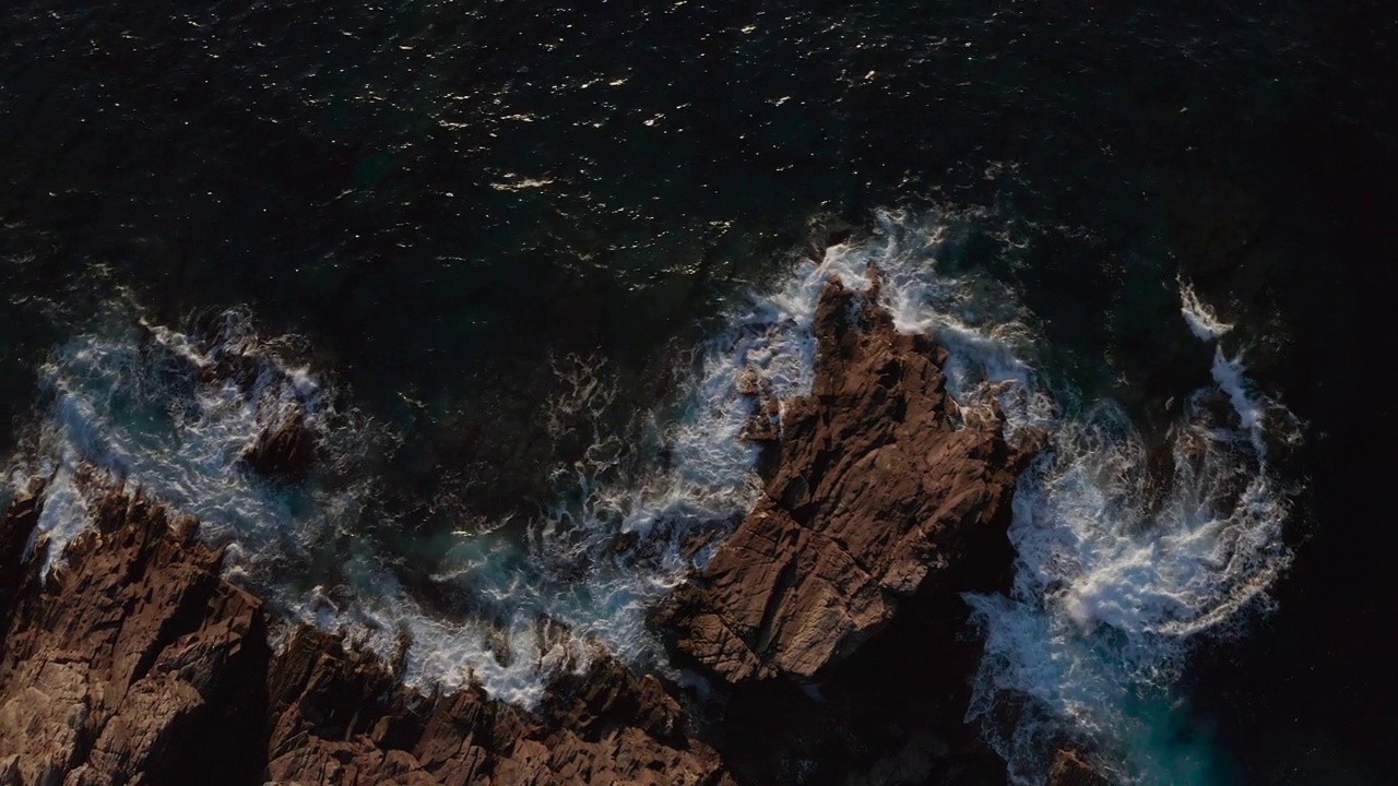 无人机航拍，海浪撞击岩石海岸。悬崖下降视图视频素材