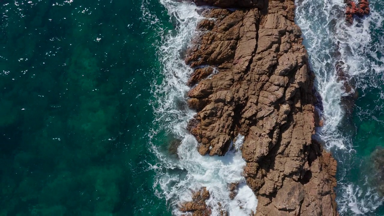 无人机航拍，海浪撞击岩石海岸。悬崖下降视图视频素材