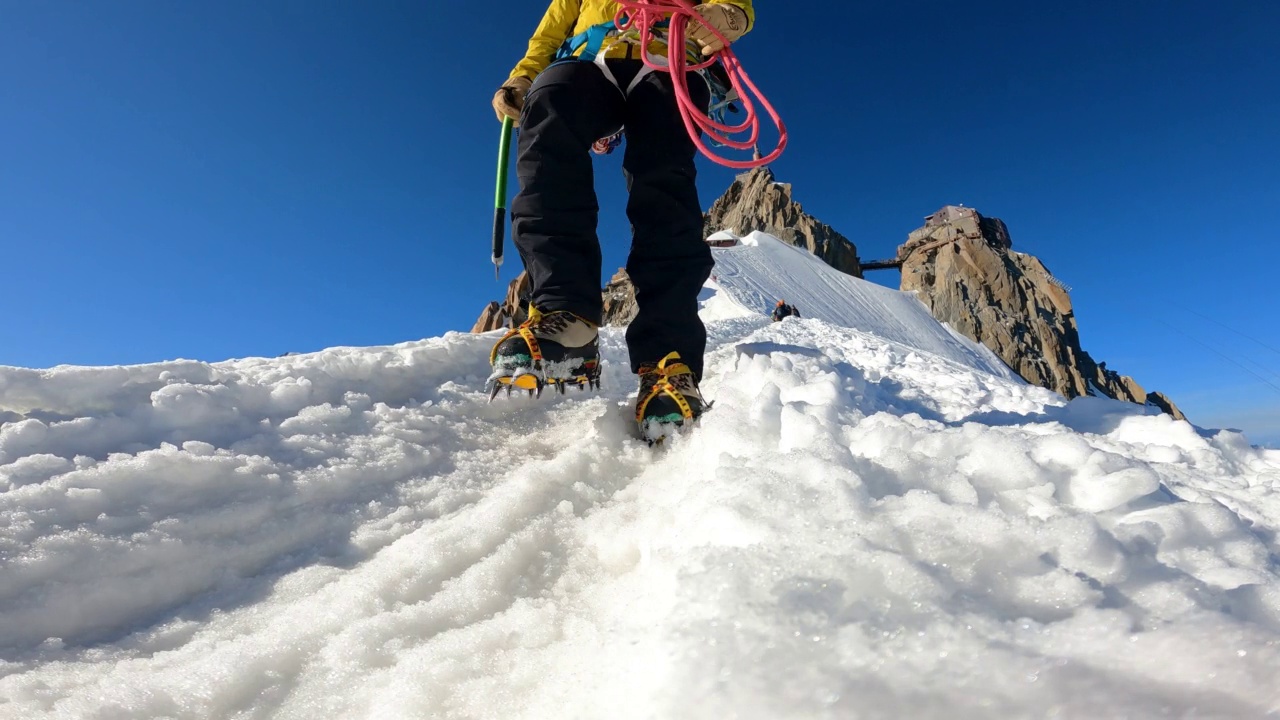 高级登山队正在向欧洲阿尔卑斯山积雪覆盖的山峰进发。靠近腿部视频素材