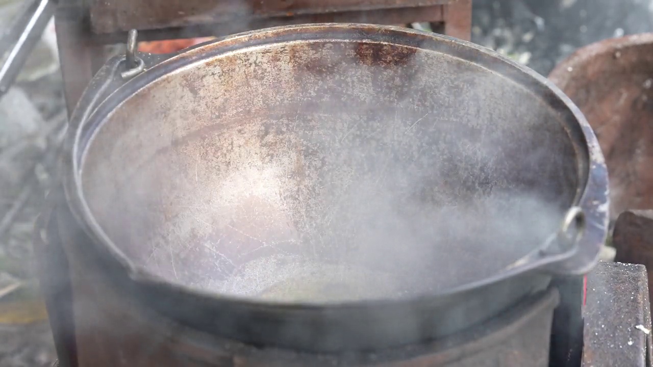 在自然的大锅里烹饪。厨师倒了油，把土豆放到火上的锅里视频素材