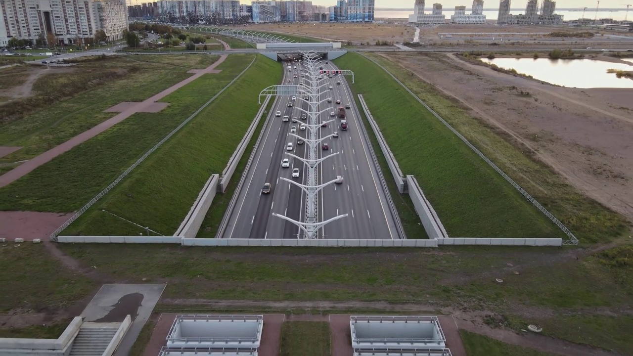 飞过市中心的多车道公路。西部高速直径在圣彼得堡。建筑物和日落的天空作为背景。视频素材