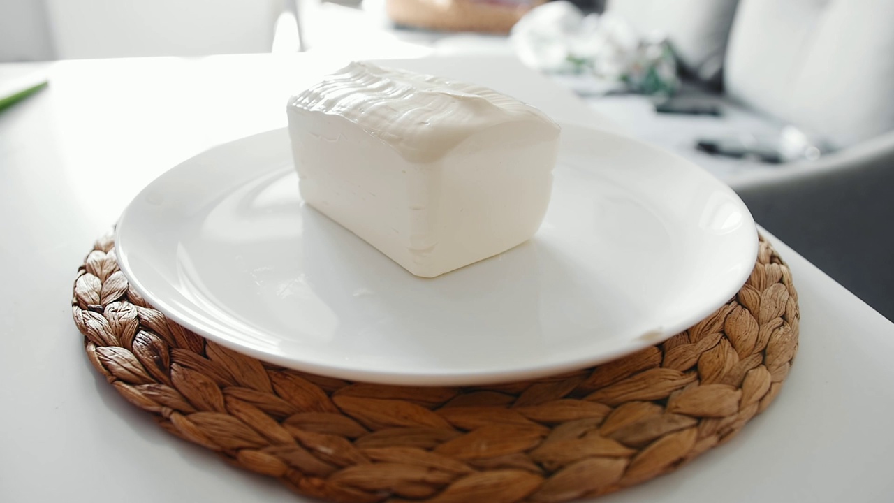 一片马苏里拉奶酪掉在厨房里的一个白色大盘子上视频下载