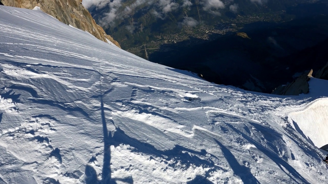 一队登山者正在攀登欧洲阿尔卑斯山的雪峰。使用绳索和攀爬设备。鸟瞰图视频素材