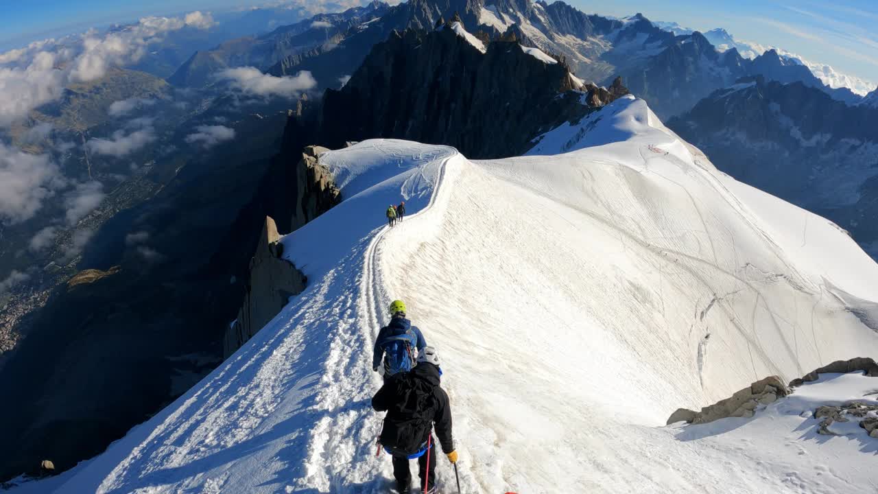 一队登山者正在攀登欧洲阿尔卑斯山的雪峰。使用绳索和攀爬设备。鸟瞰图视频素材